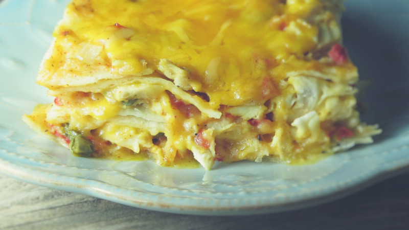 closeup up of the layers of corn tortillas, sauce and cheese