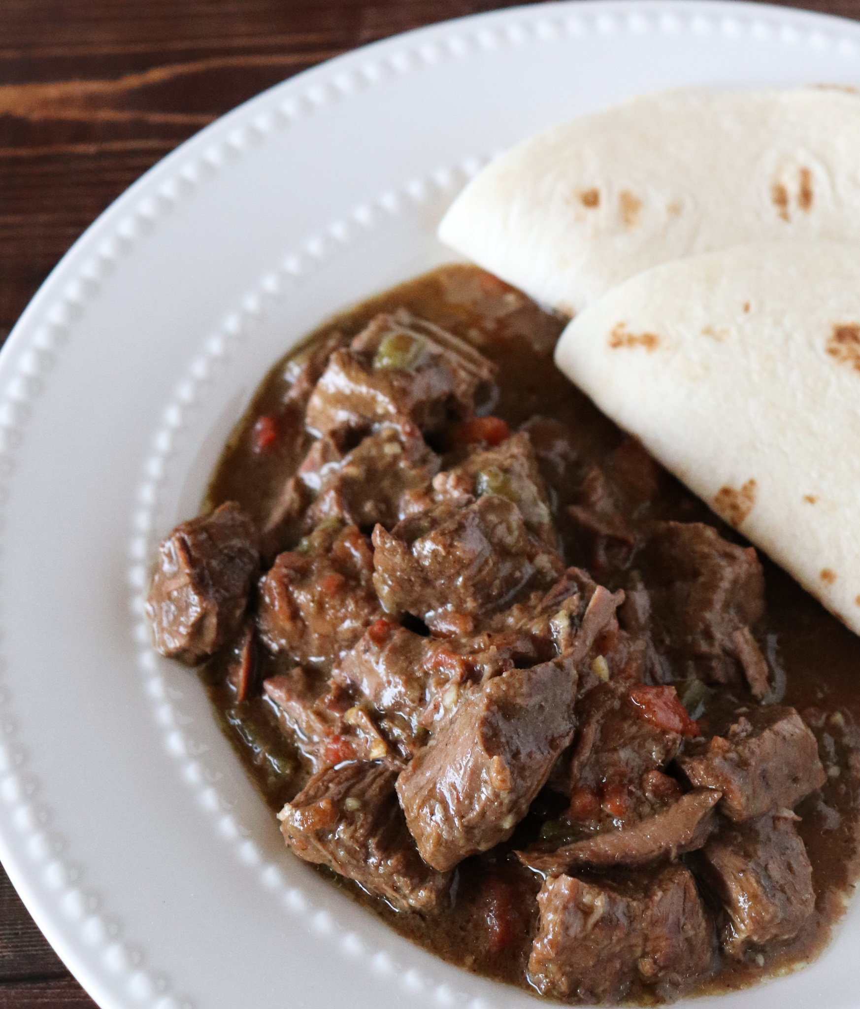 carne guisada plated with flour tortillas