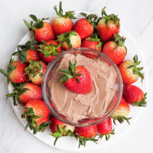 prepared creamy chocolate cheesecake dip surrounded by fresh strawberries