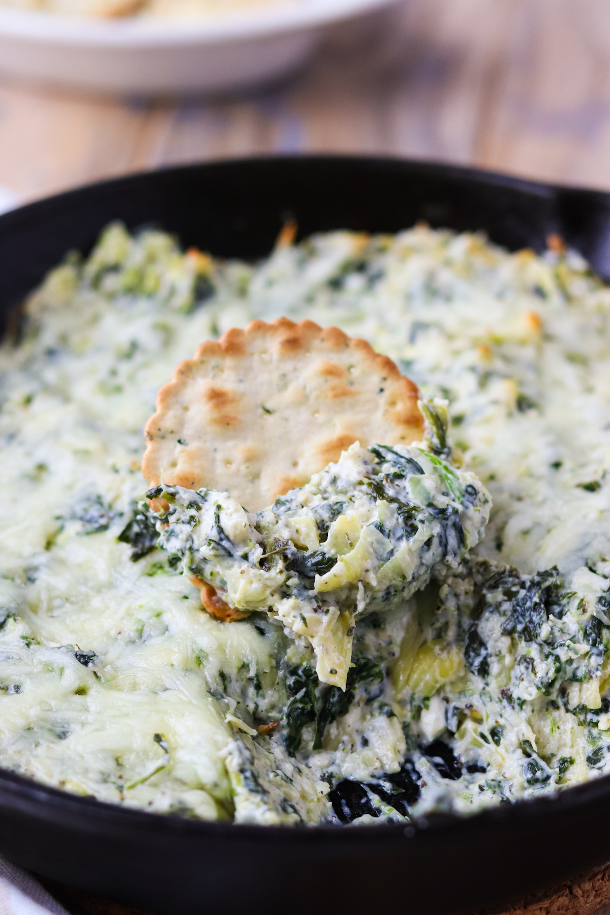 cracker topped with spinach artichoke dip