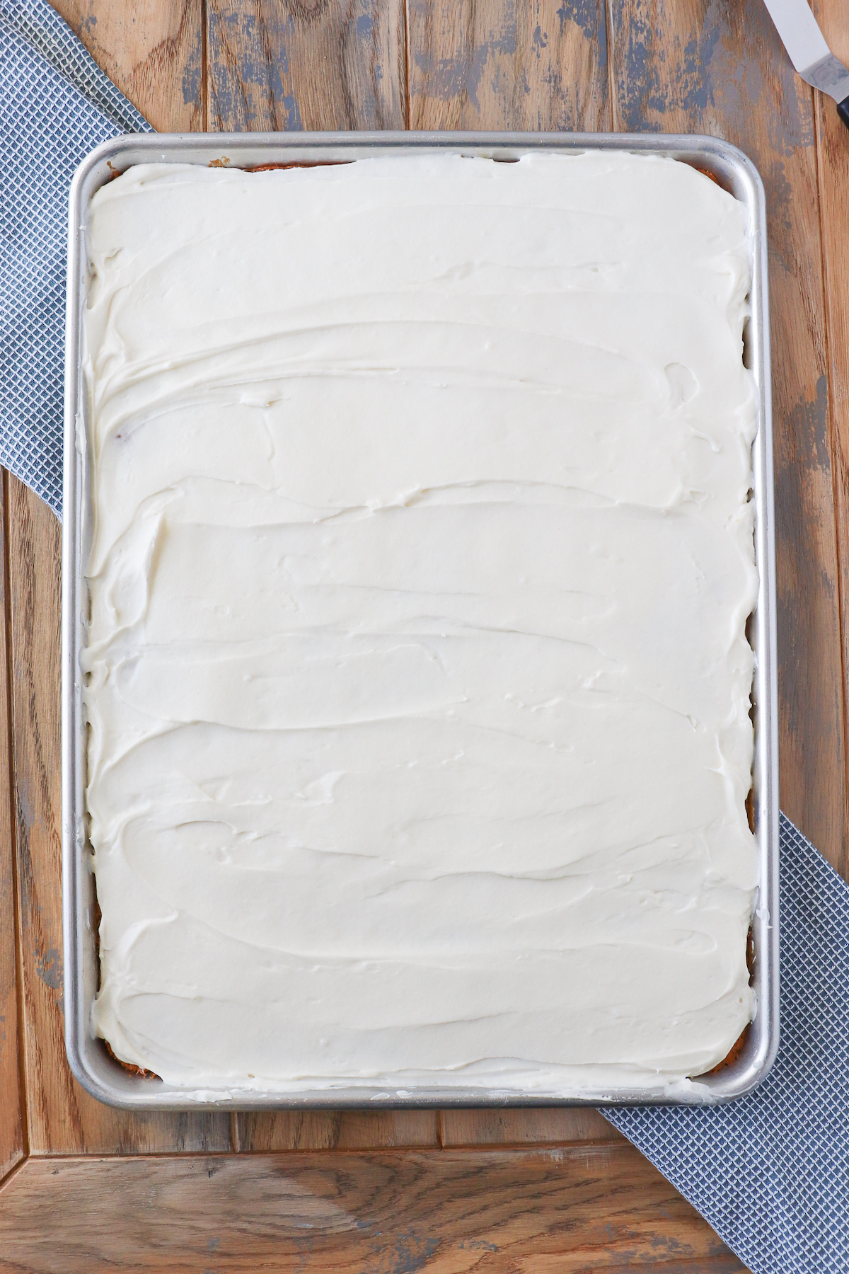 half sheet pan of baked and frosted banana bars