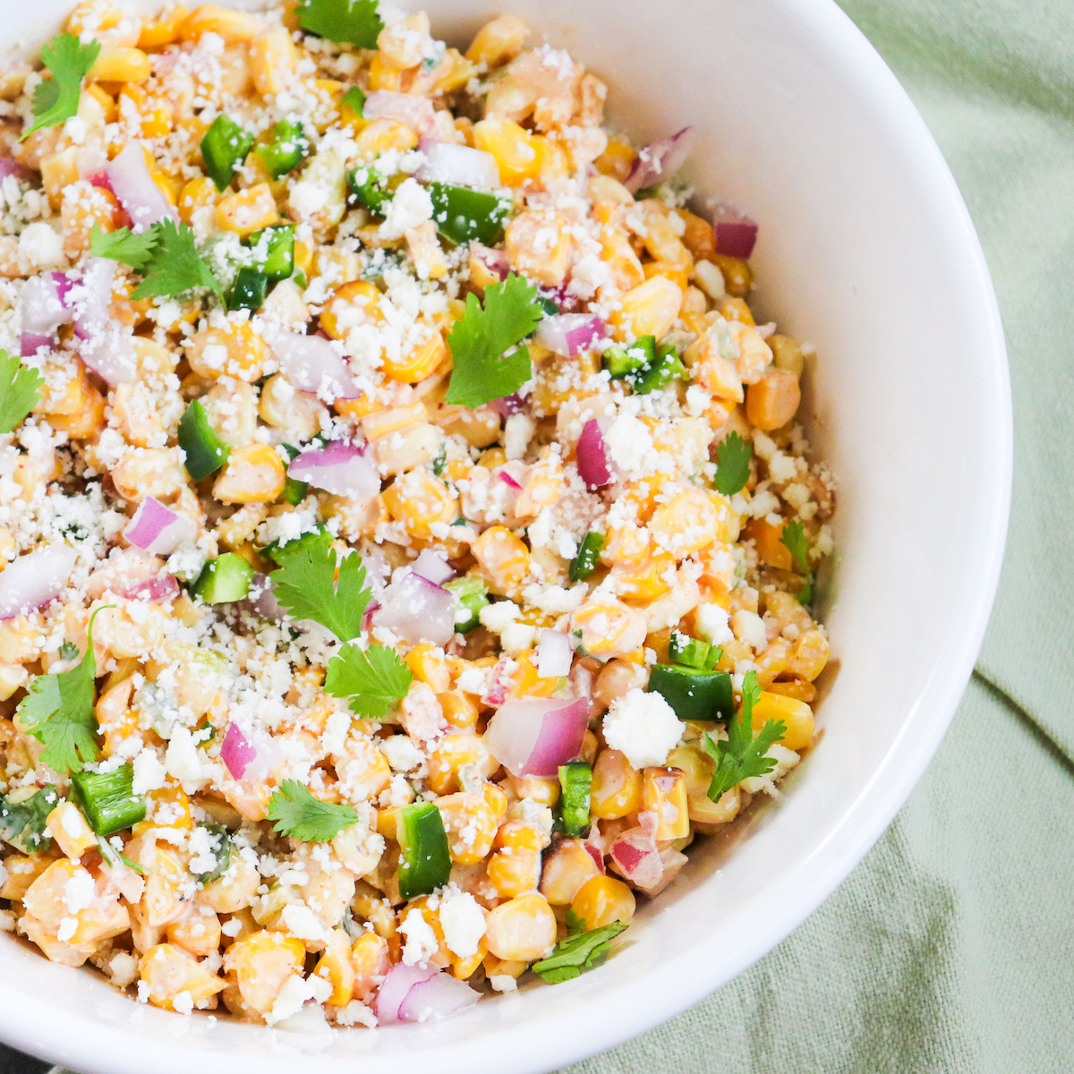 grilled corn, cortina cheese, red onion and cilantro in a bowl