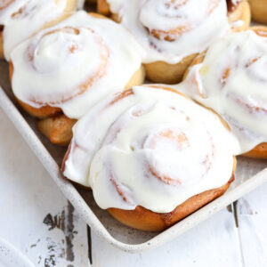 angled closeup of whole wheat cinnamon roll with cream cheese frosting on top