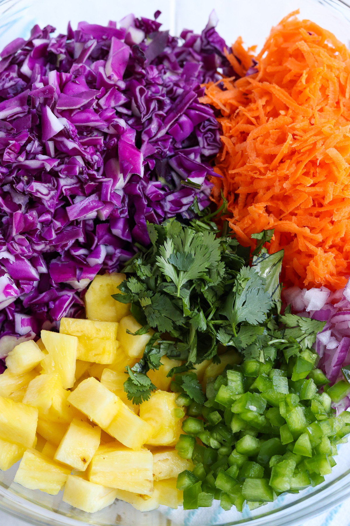 bowl of chopped red cabbage, shredded carrots, onion, jalapeno, pineapple and cilantro