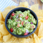 closeup of authentic prepared homemade guacamole with tortilla chips