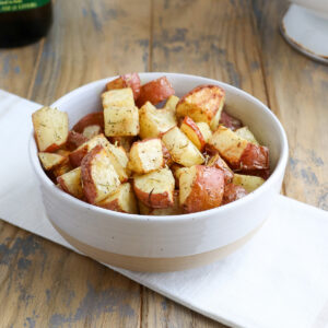 bowl of cooked roasted red potatoes with golden brown spots and visible rosemary