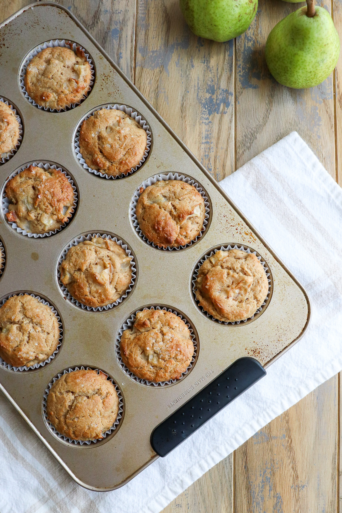 baked golden brown pear muffins in muffin tin