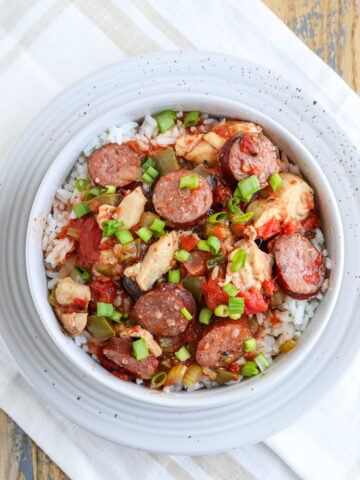 bowl of rice topped with a easy sausage chicken jambalaya and green onions