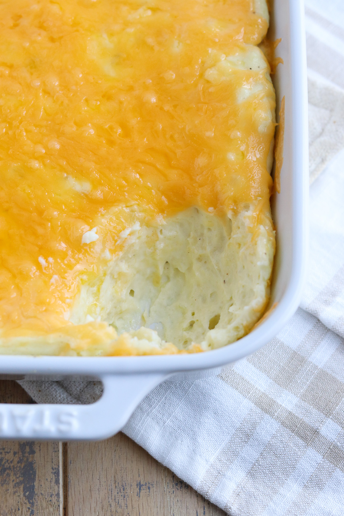 casserole dish of potatoes with a scoop missing