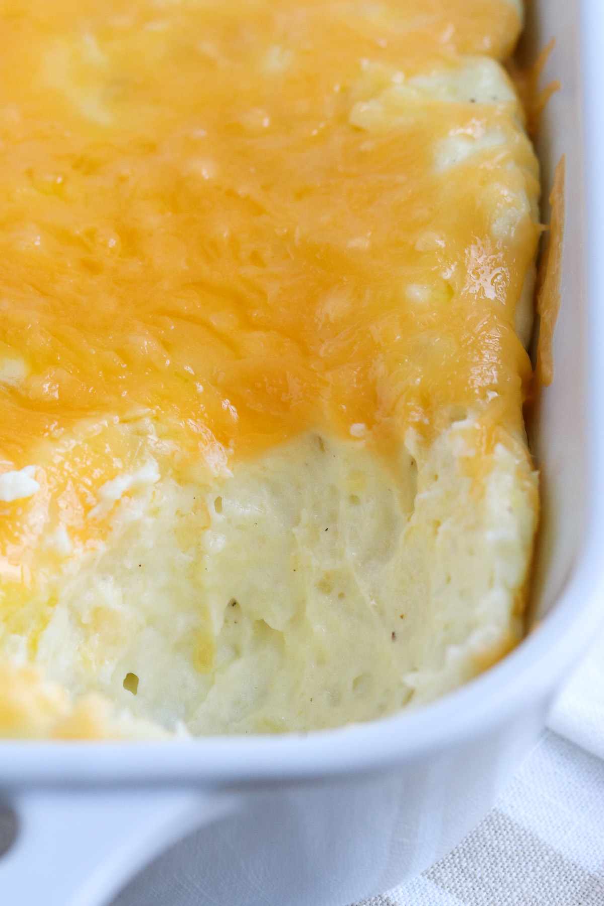 closeup of creamy potatoes with bubbly cheddar cheese on top