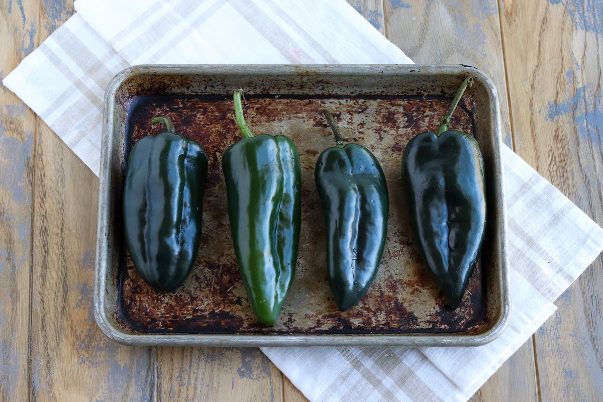 green poblano Chile peppers on a baking sheet