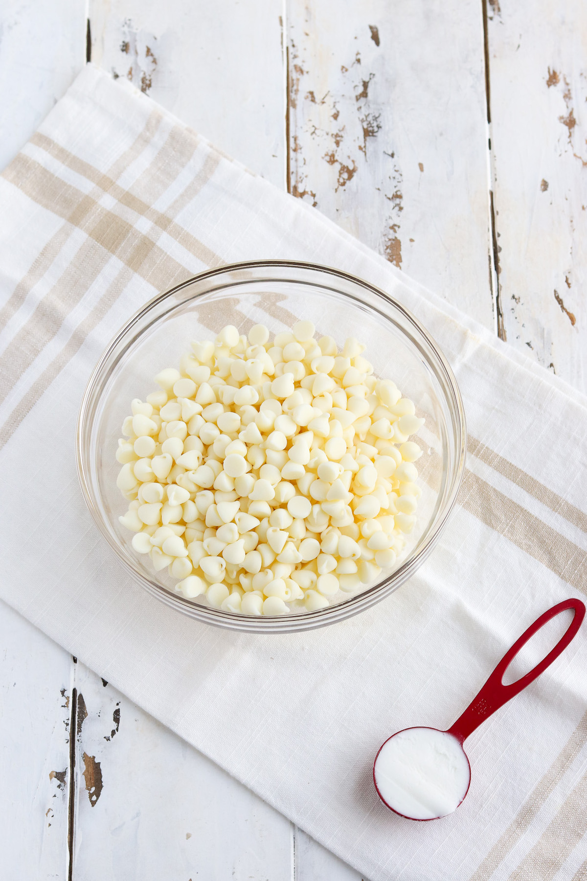 glass bowl of white chocolate chips and one tablespoon of shortening