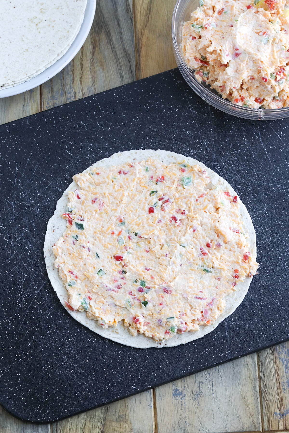 wrap with pimento cheese spread on it laying flat on cutting board