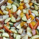 closeup of herbs on roasted veggies on sheet pan