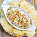 serving dish of pickle dip with crispy onions and potato chips
