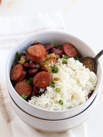 serving bowl of white rice topped with cajun red beans and sausage