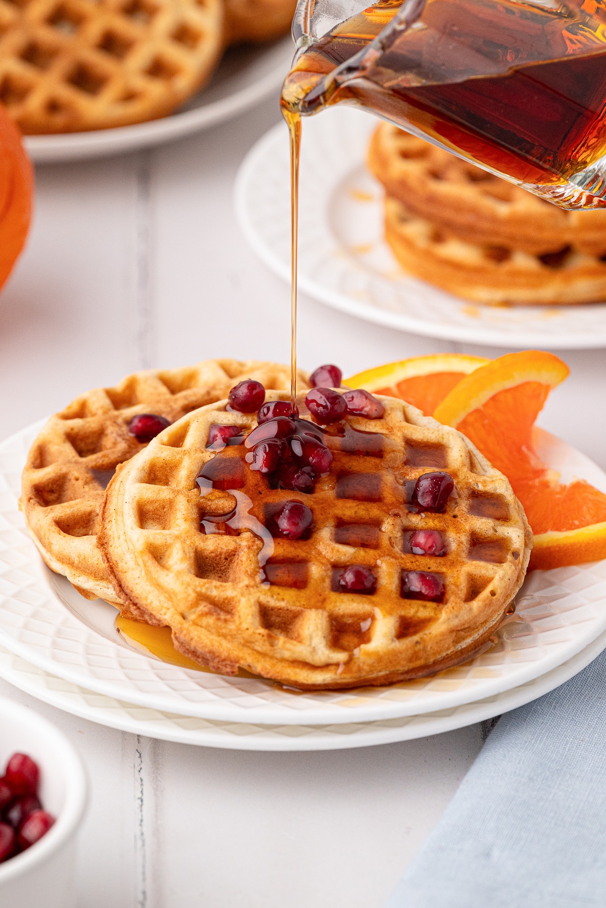 syrup being poured onto waffles