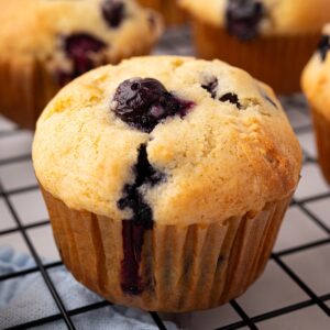 closeup of blueberry muffin with golden brown top and juicy blueberries