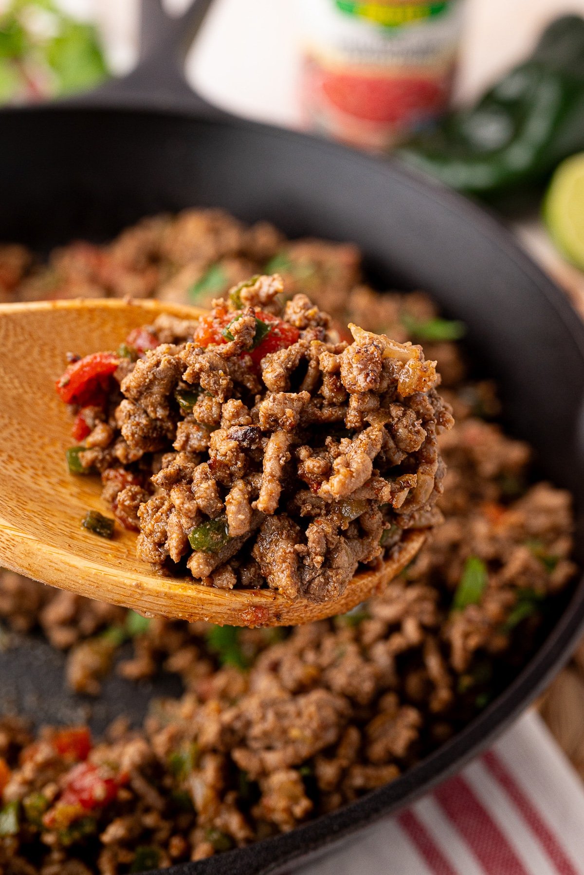 savory ground beef taco meat cooked in cast iron on a wooden spoon