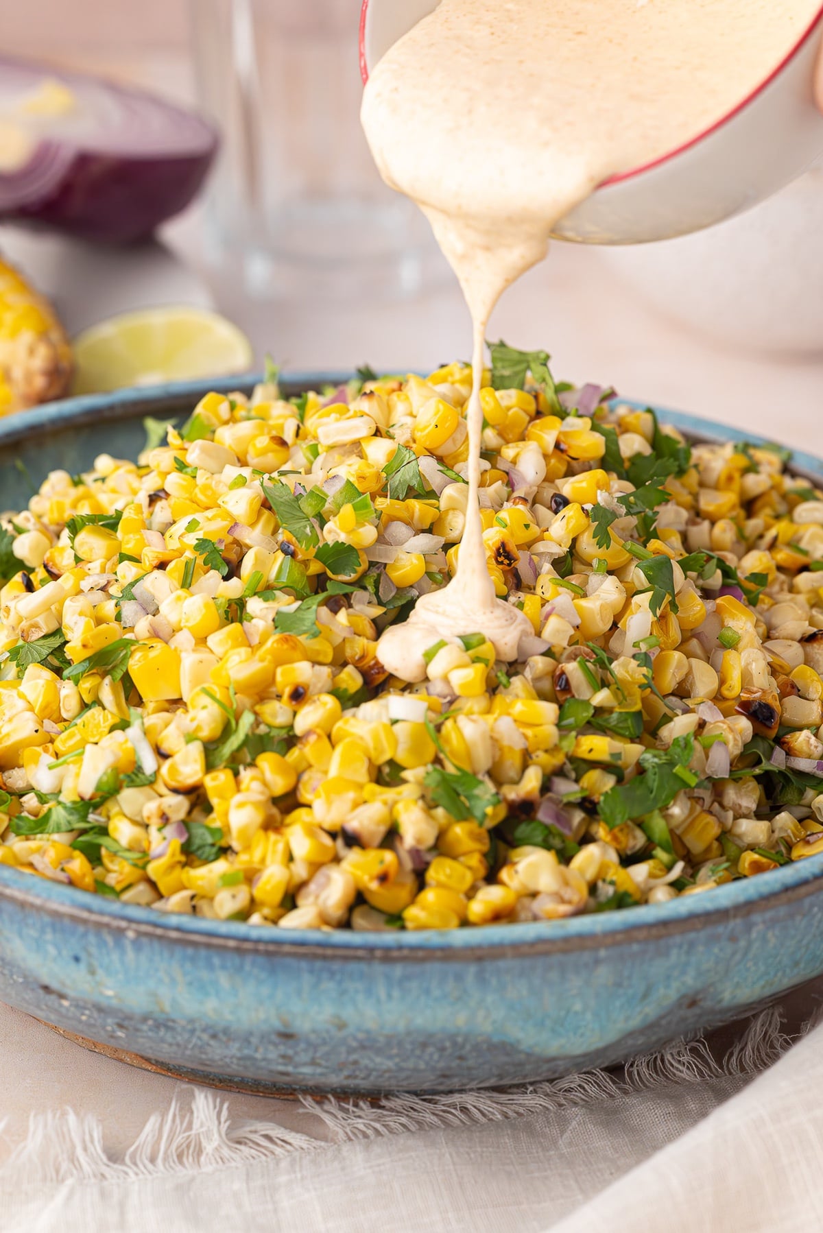 pouring dressing on street corn salad