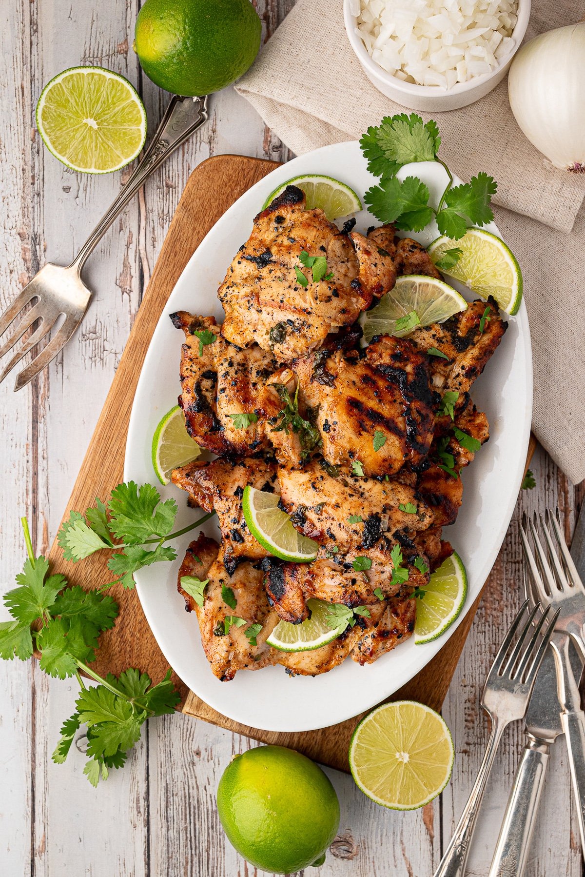 grilled chicken thighs garnished with cilantro and lime