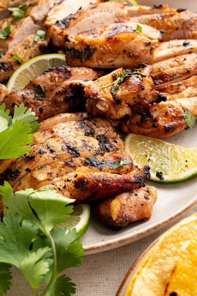 sliced grilled chicken thighs on a platter