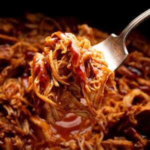 juicy shredded bbq chicken on a fork over crock pot