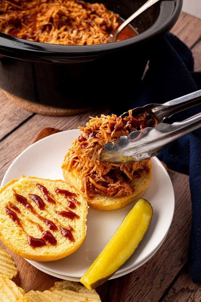placing bbq chicken on bun
