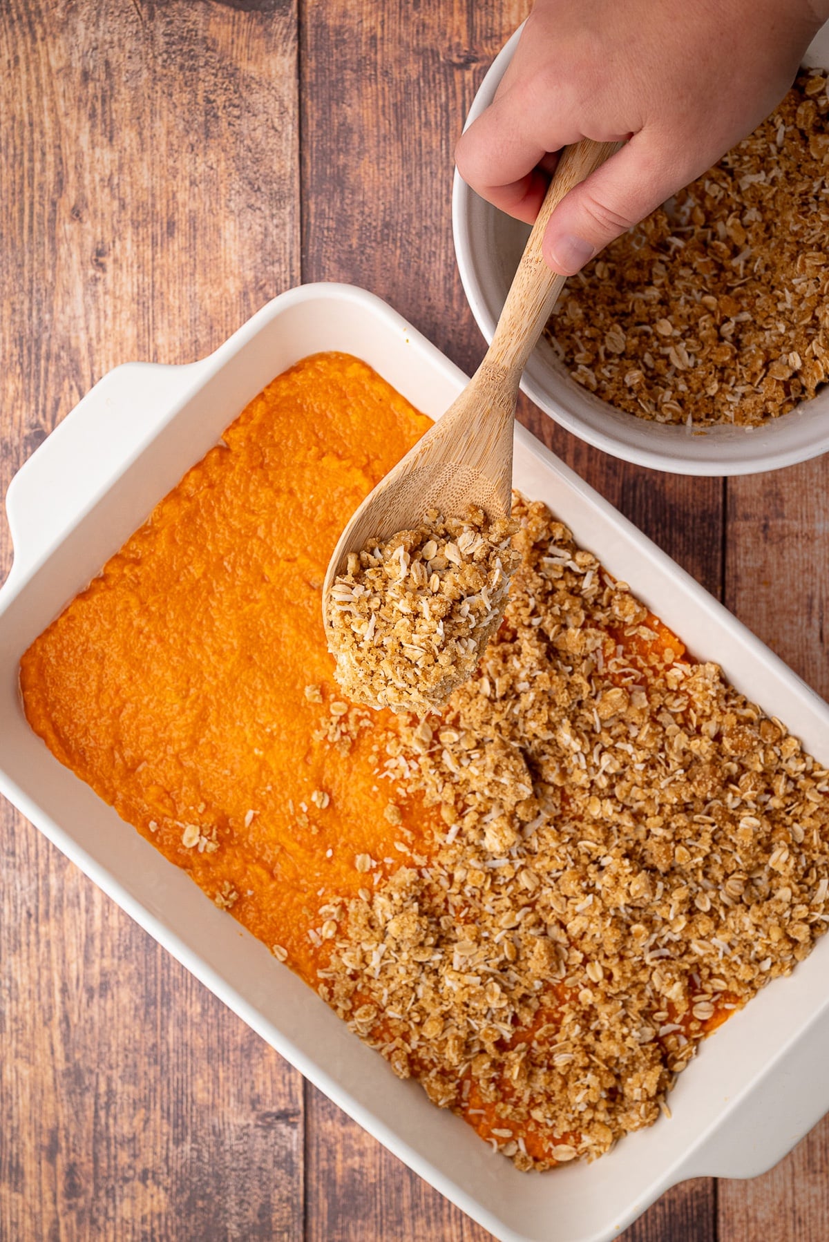 spooning topping on top of sweet potato layer