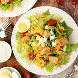 plated Texas Roadhouse Copycat Salad on white plate with ranch, croutons, eggs, tomatoes and lettuce