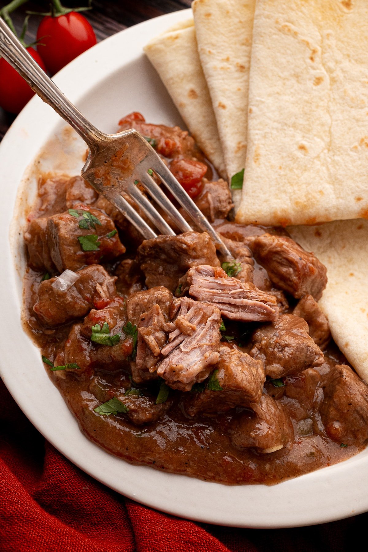 savory texas style carne guisada plated with flour tortillas