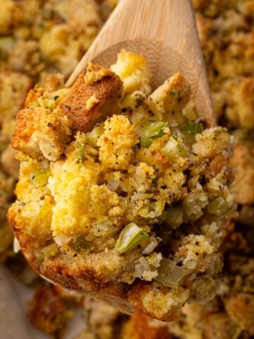 a serving spoon of southern cornbread dressing over the casserole dish