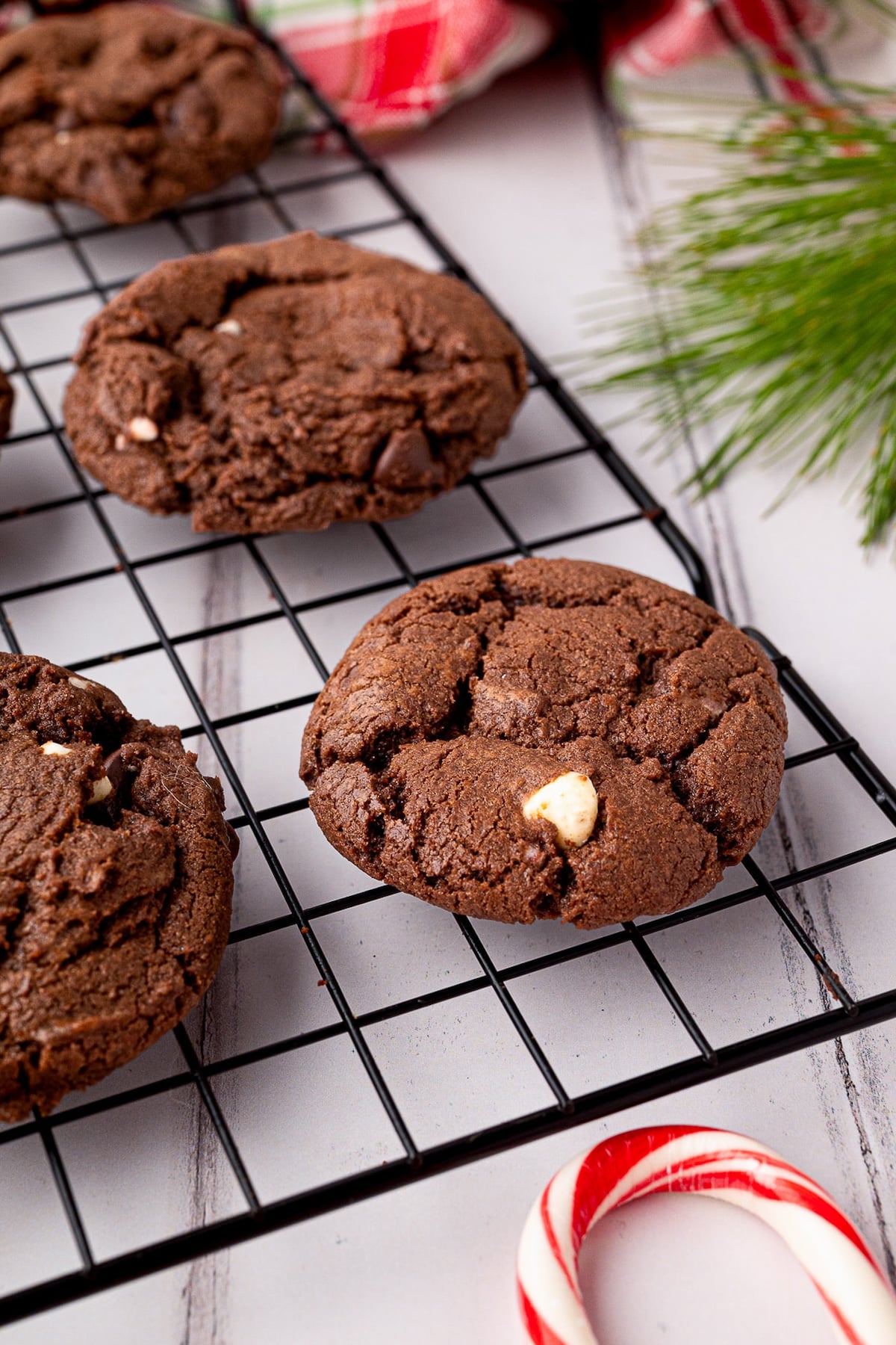 Rich dark chocolate cookie cooling on a black wire rack.