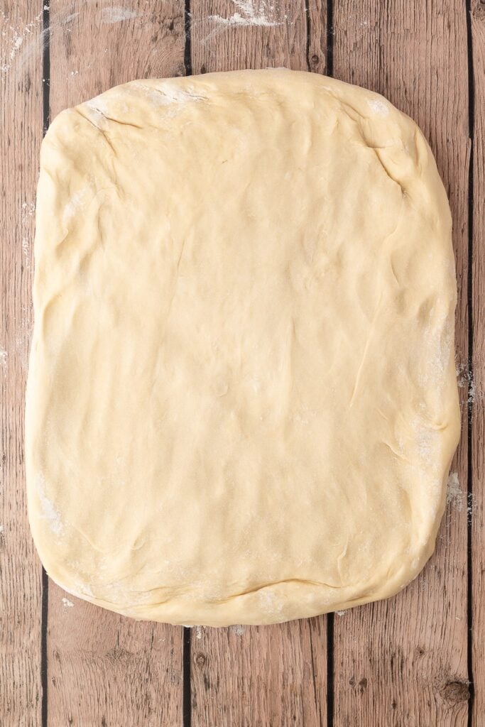The fluffy dough patted out in to the shape of a rectangle.