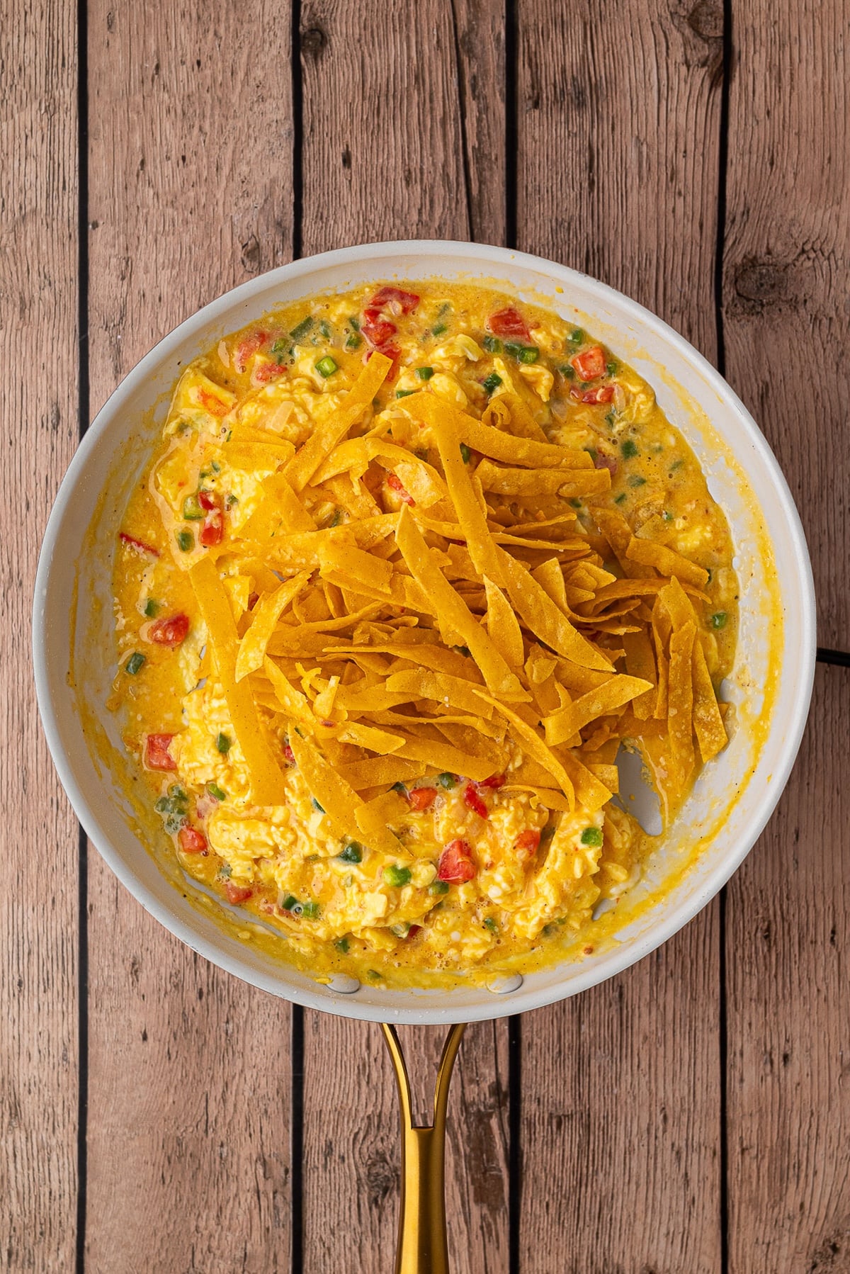 Adding corn tortilla strips back to egg and veggie mixture in skillet.
