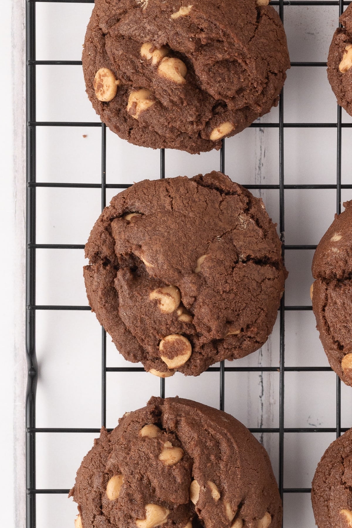 Chocolate and Reese's chip drop cookies freshly baked on a wire rack.