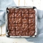 Easy homemade chocolate brownies with a shiny crinkle-top and fudgy center cut into squares in a parchment-lined baking pan, a 5 star favorite from My Texas Kitchen.