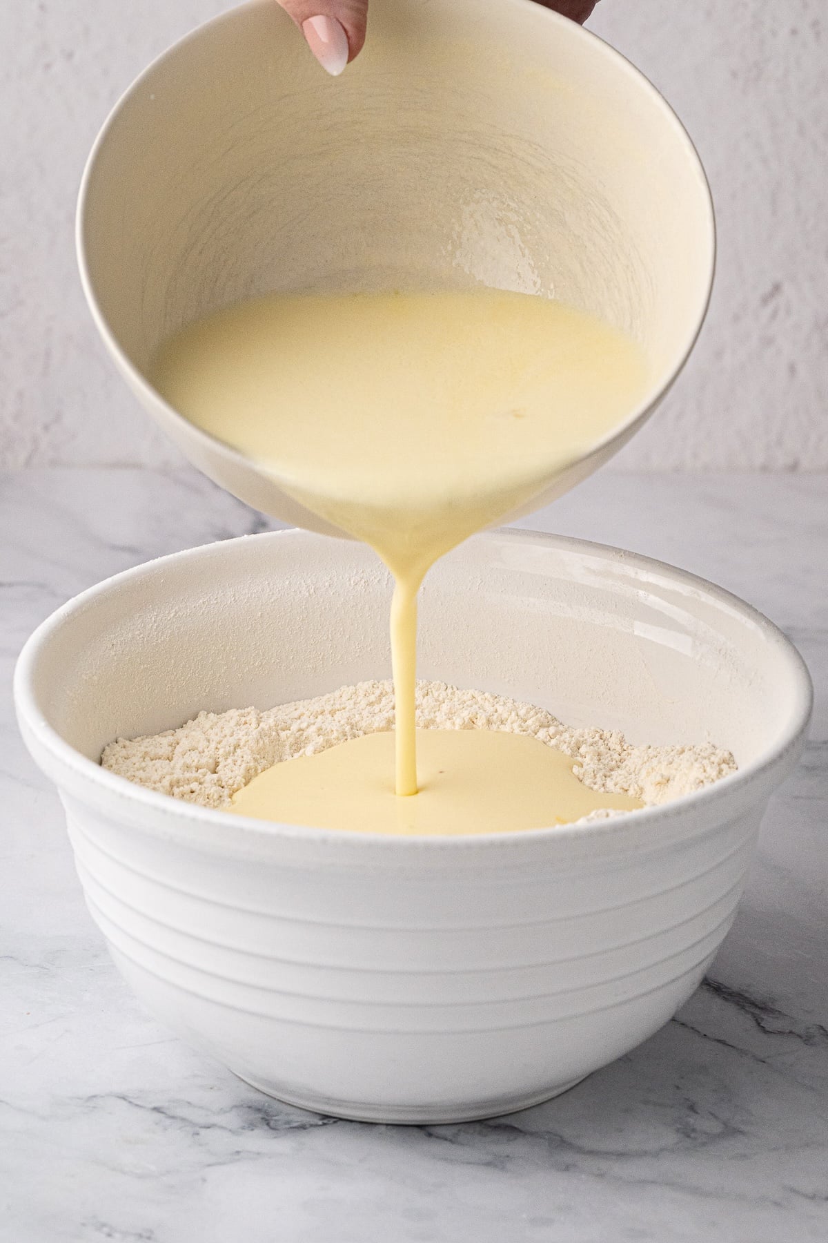 Creating a well in the center of dry flour ingredients before slowly adding the buttermilk mixture.