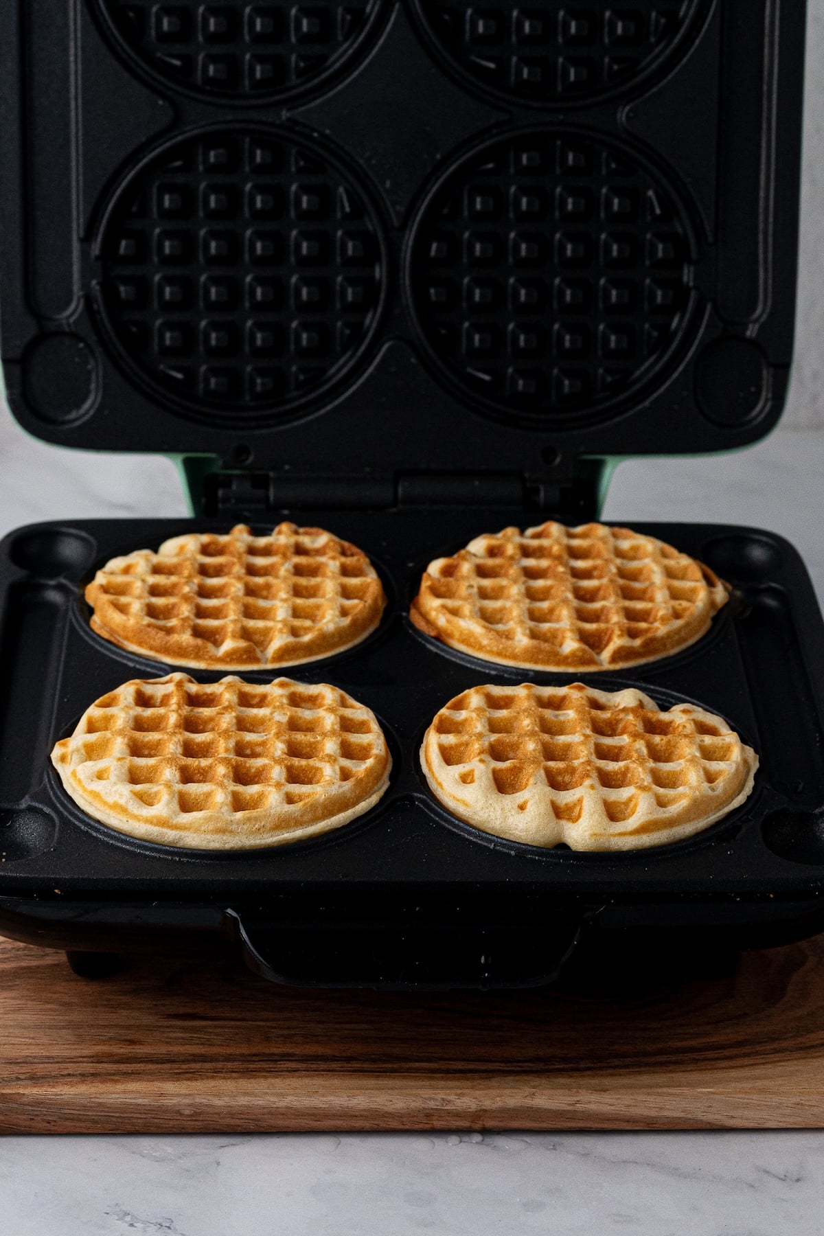 Cooking batter in waffle iron until waffles are golden brown with crispy edges.