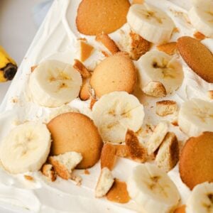 A close-up of cold, no-bake banana pudding showing thick layers of fresh fruit, creamy vanilla pudding, and softened vanilla wafers.