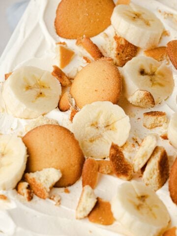 A close-up of cold, no-bake banana pudding showing thick layers of fresh fruit, creamy vanilla pudding, and softened vanilla wafers.