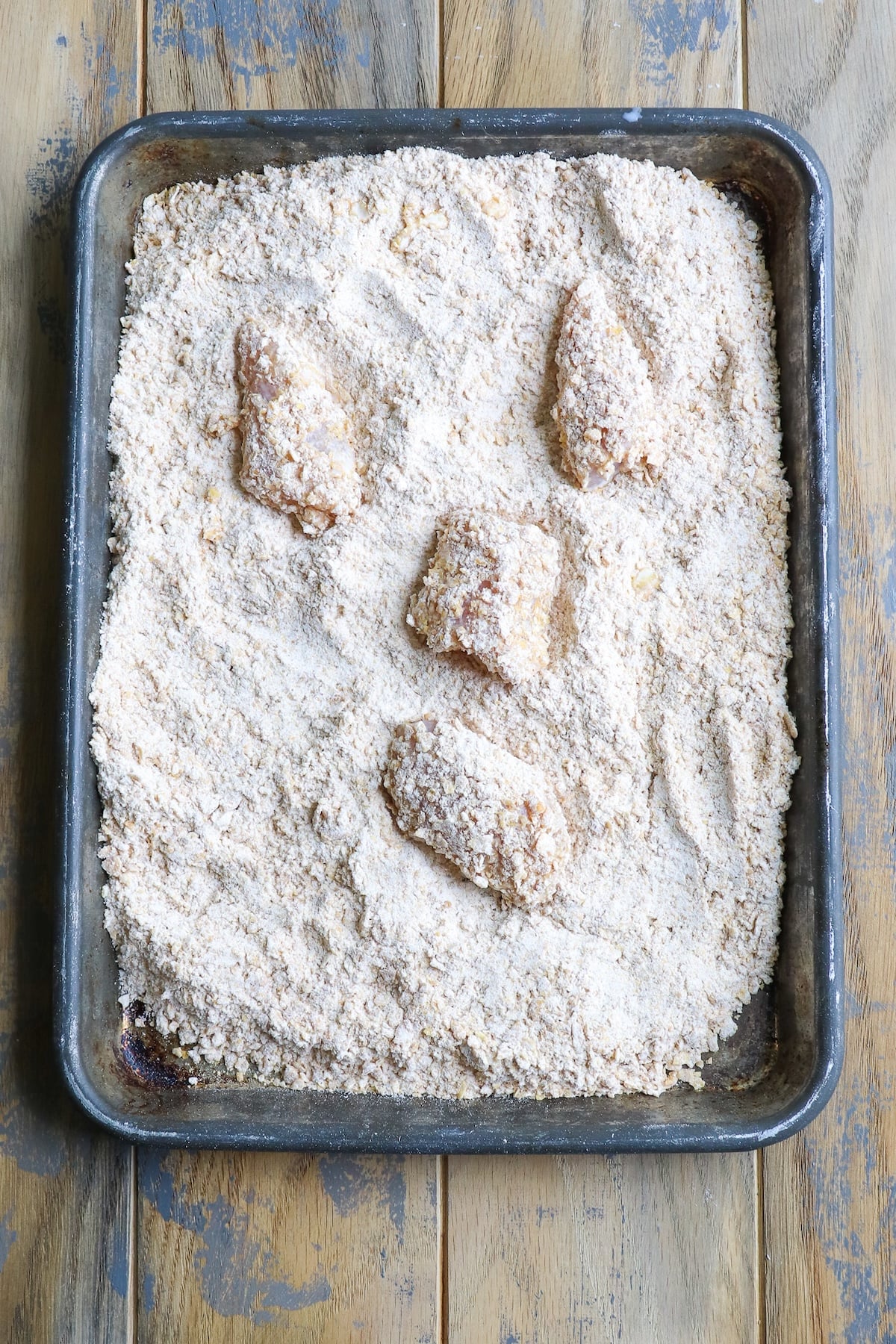 Chicken into a shallow dish filled with a seasoned mixture of crushed cornflakes and all-purpose flour.