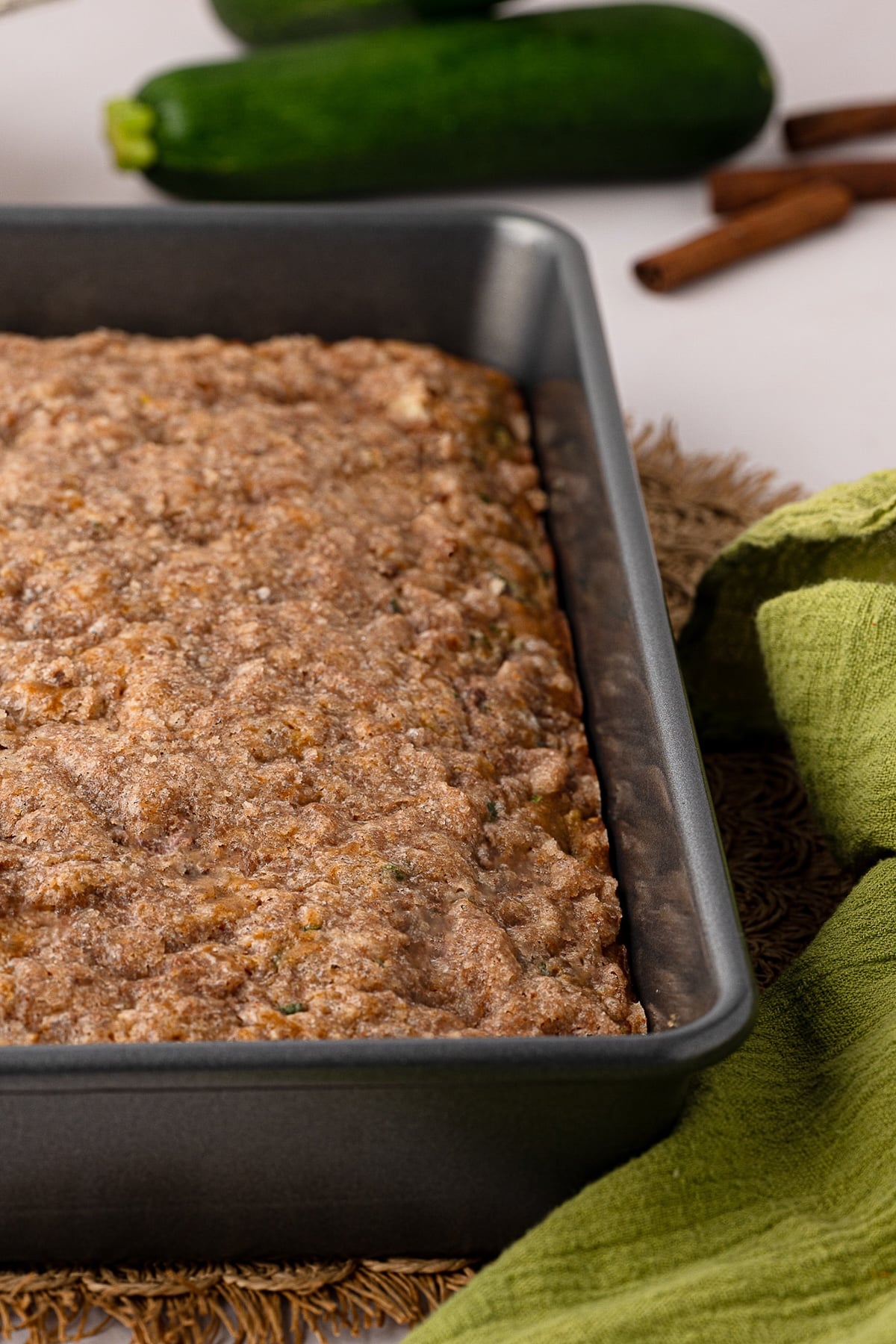 A macro close-up view of the crisp, sparkling cinnamon sugar crackle topping on top of a freshly baked zucchini cake.