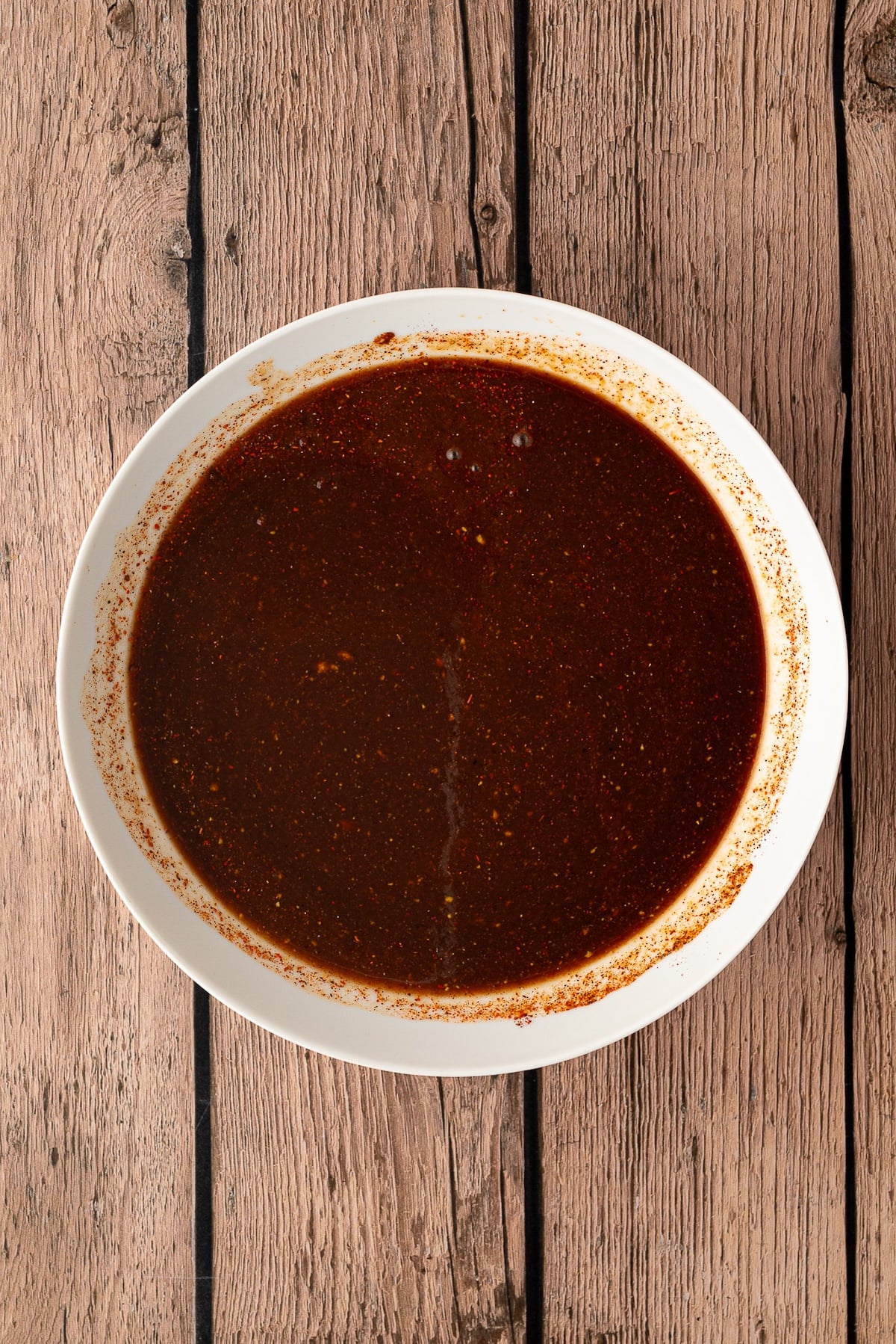 Pineapple juice, BBQ sauce, and spices mixed together in a bowl.