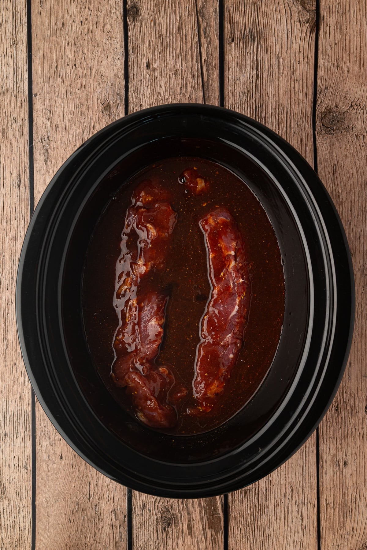 Pork tenderloins coated in pineapple BBQ sauce and placed in slow cooker.