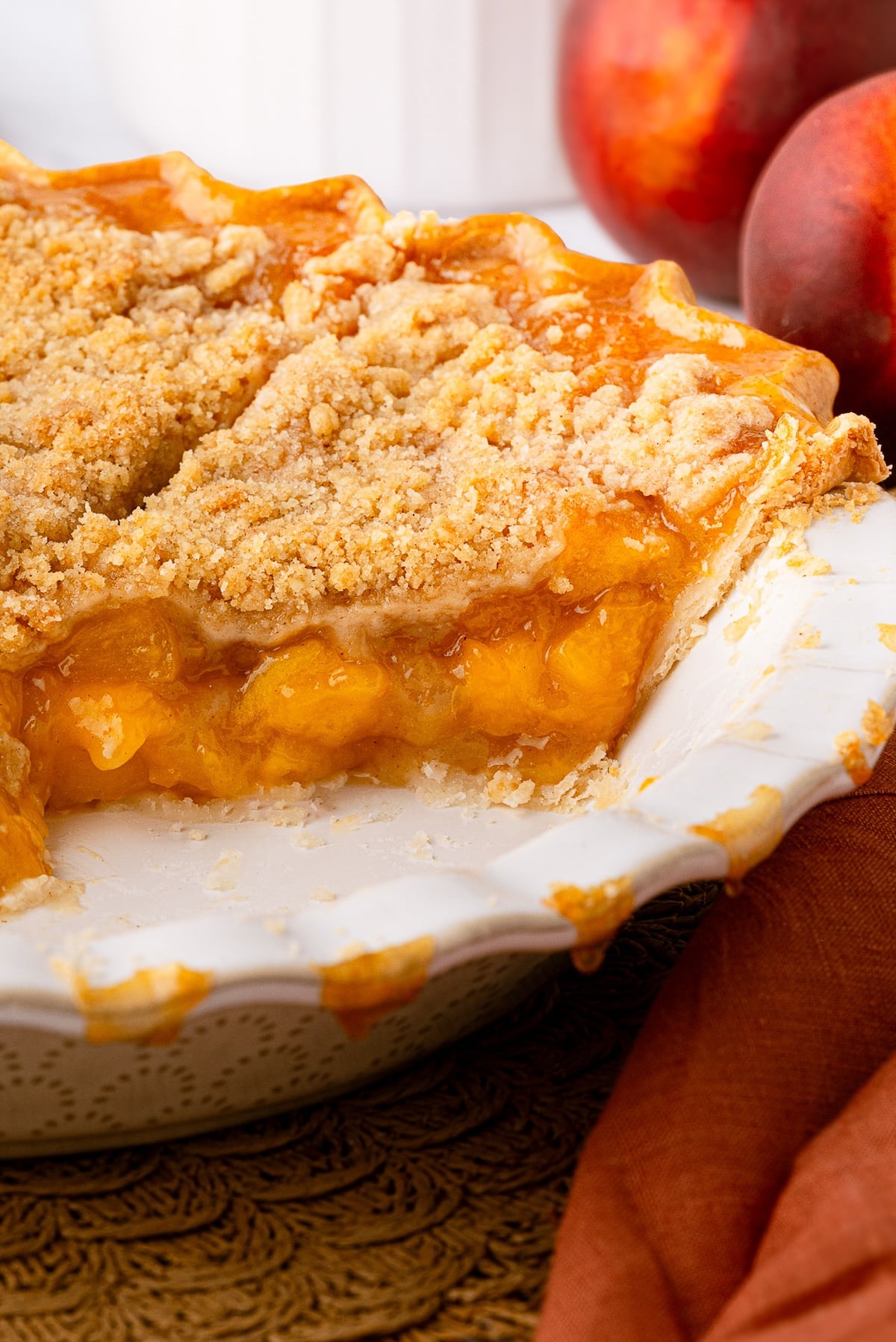 A golden-brown Texas peach crumble pie with a crisp, buttery streusel topping, served in a deep-dish pie plate.