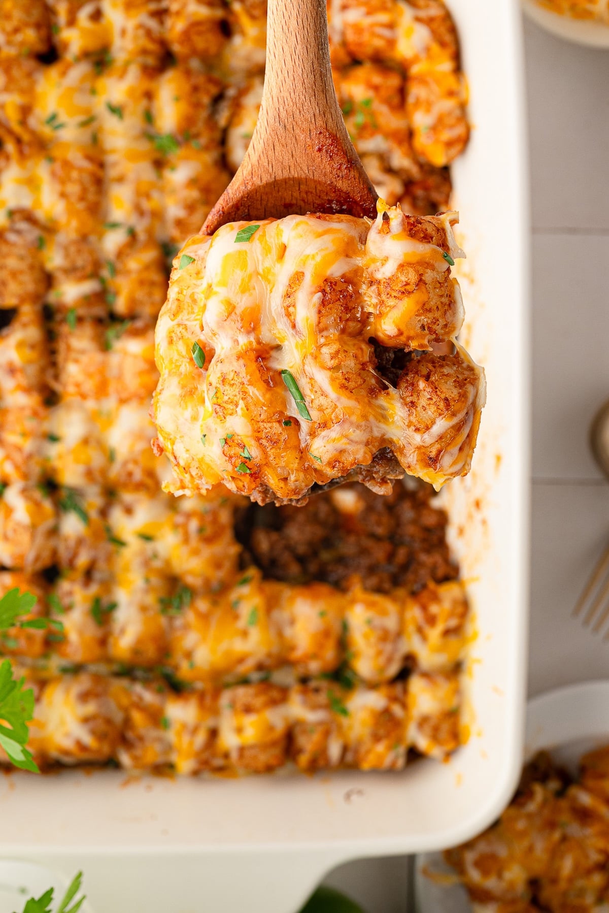 Crispy tater tots with bubbling cheddar cheese top the baked sloppy Joe casserole.