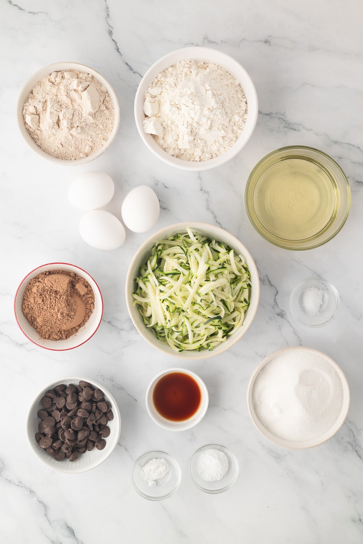 Ingredients needed for chocolate zucchini bread individually in bowls.