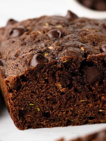 Close-up of sliced chocolate zucchini bread showing the moist chocolate crumb and chocolate chips.