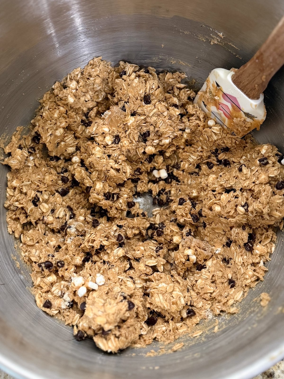 Stand mixer bowl after adding in the chocolate chips to energy bites mixture.